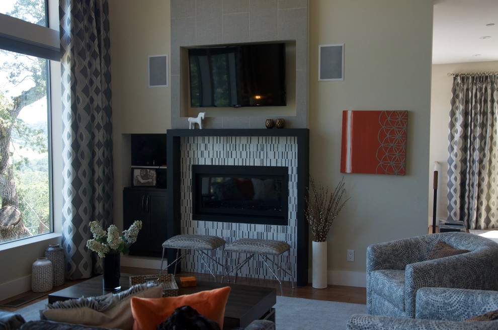 Mittelgroßes, Offenes Modernes Wohnzimmer mit beiger Wandfarbe, braunem Holzboden, Kamin, gefliester Kaminumrandung und TV-Wand in San Francisco