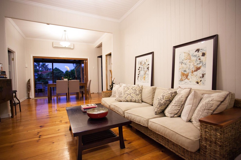 Small country open plan living room in Brisbane with medium hardwood flooring and no fireplace.