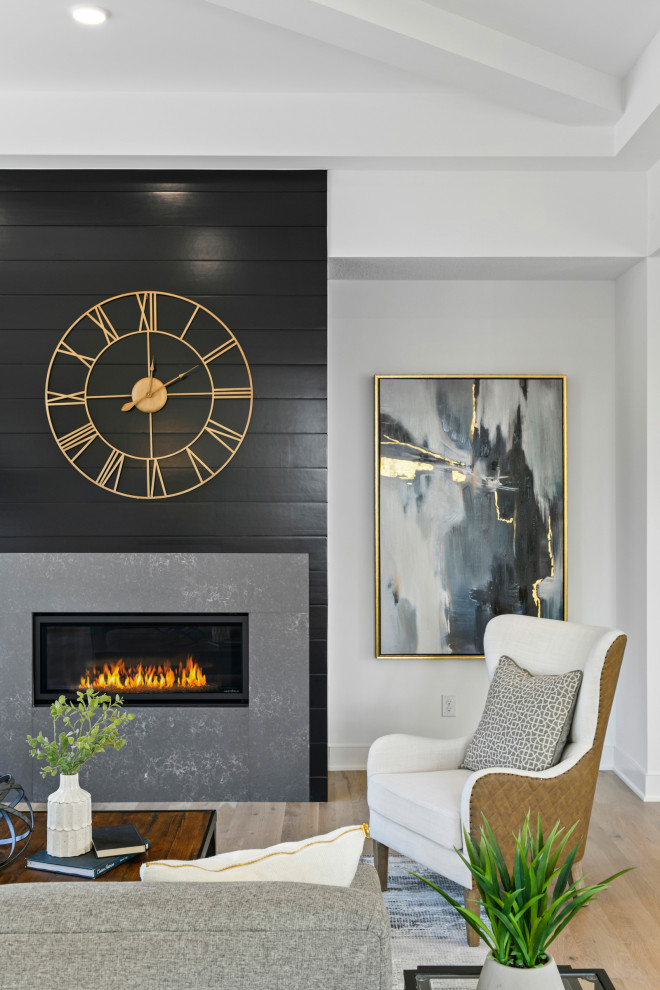 ミネアポリスにある高級な中くらいなトランジショナルスタイルのおしゃれなリビング (白い壁、淡色無垢フローリング、横長型暖炉、塗装板張りの暖炉まわり、壁掛け型テレビ、茶色い床) の写真