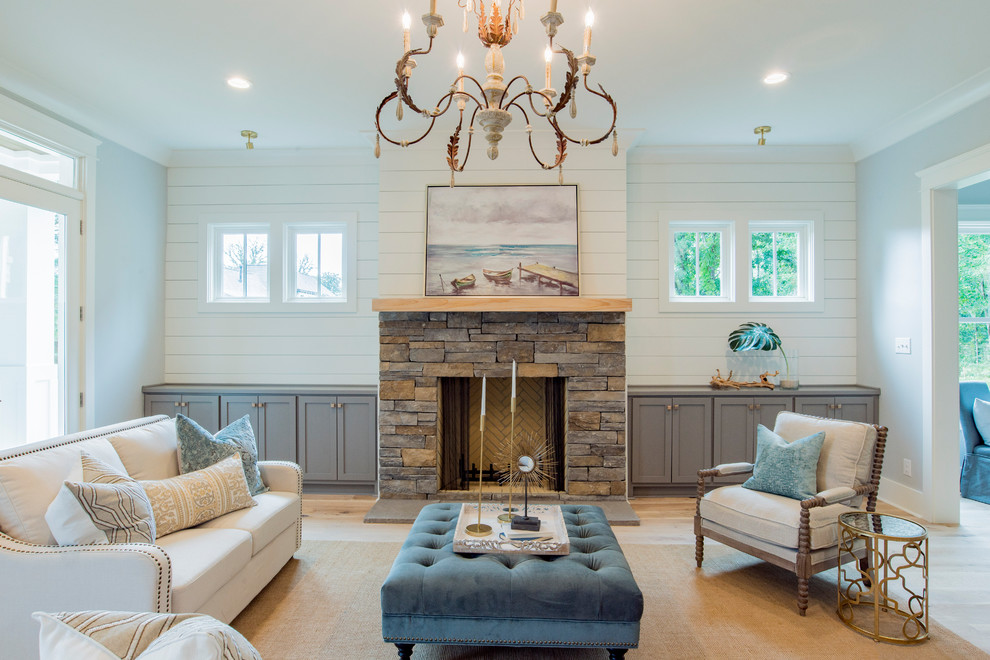 Repräsentatives Klassisches Wohnzimmer mit blauer Wandfarbe, hellem Holzboden, Kamin, Kaminumrandung aus Stein und beigem Boden in Sonstige