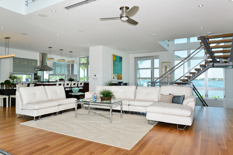 Großes, Offenes Wohnzimmer ohne Kamin mit weißer Wandfarbe und braunem Holzboden in Tampa