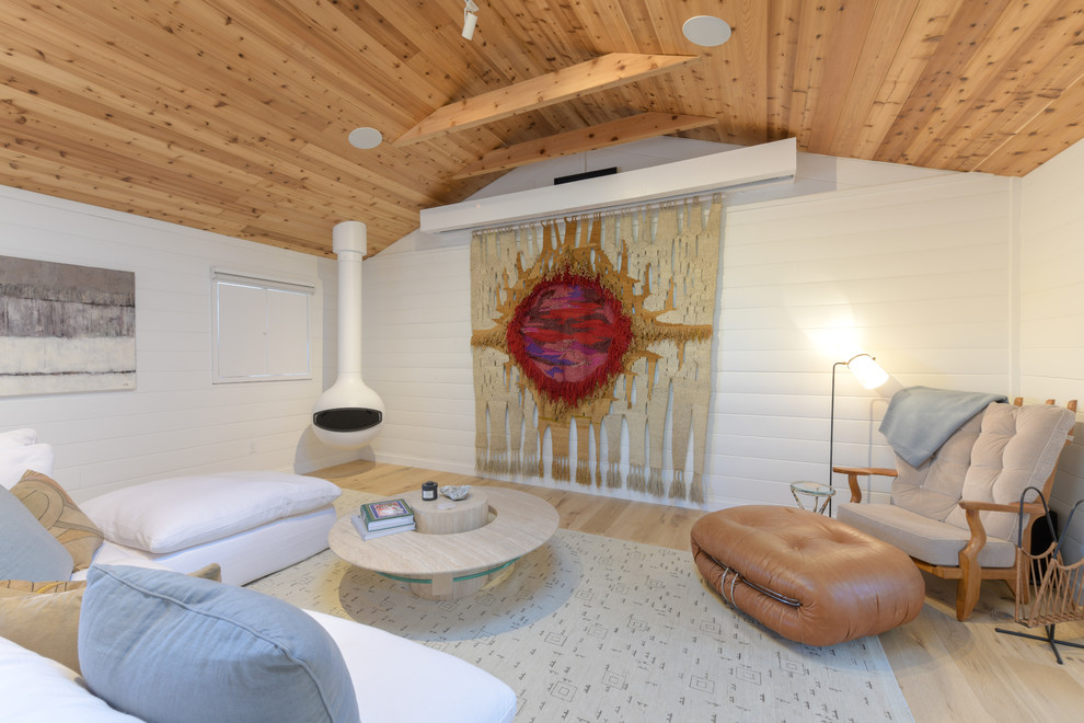 На фото: открытая гостиная комната в морском стиле с белыми стенами, светлым паркетным полом, подвесным камином и бежевым полом