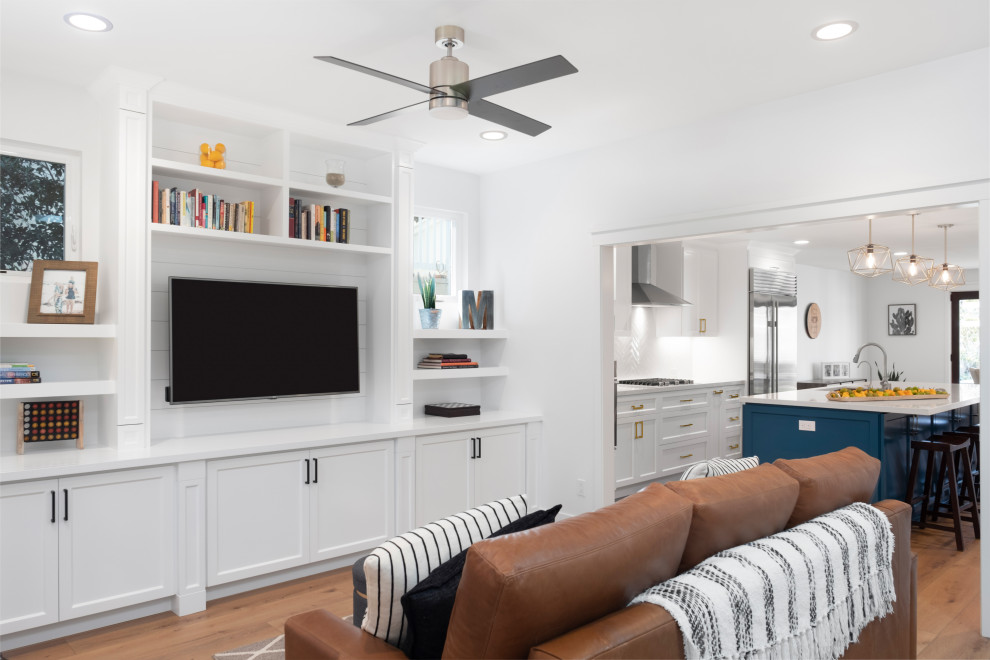 Exemple d'un très grand salon tendance ouvert avec un mur blanc, un sol en bois brun, un téléviseur encastré et un sol marron.