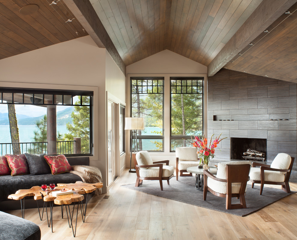 Aménagement d'un salon contemporain ouvert avec un sol en bois brun, une cheminée standard, un manteau de cheminée en carrelage, un mur beige, aucun téléviseur et un sol beige.