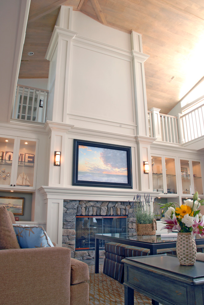 Imagen de salón abierto de estilo americano grande con paredes blancas, suelo de madera clara, todas las chimeneas, marco de chimenea de piedra y televisor retractable