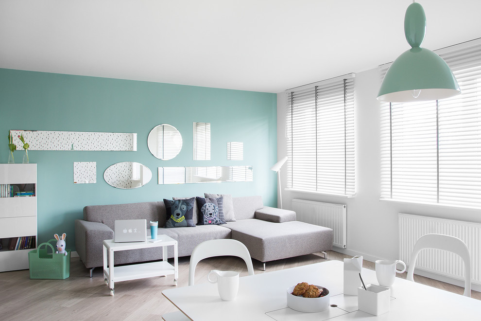 Идея дизайна: гостиная комната в современном стиле с синими стенами и светлым паркетным полом