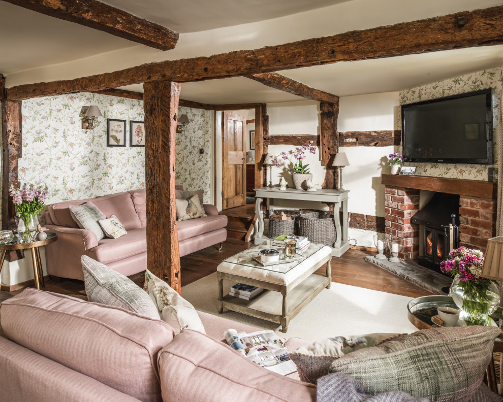 Shabby-chic style open plan living room in Oxfordshire with multi-coloured walls, dark hardwood flooring, a standard fireplace, a brick fireplace surround, a wall mounted tv and brown floors.