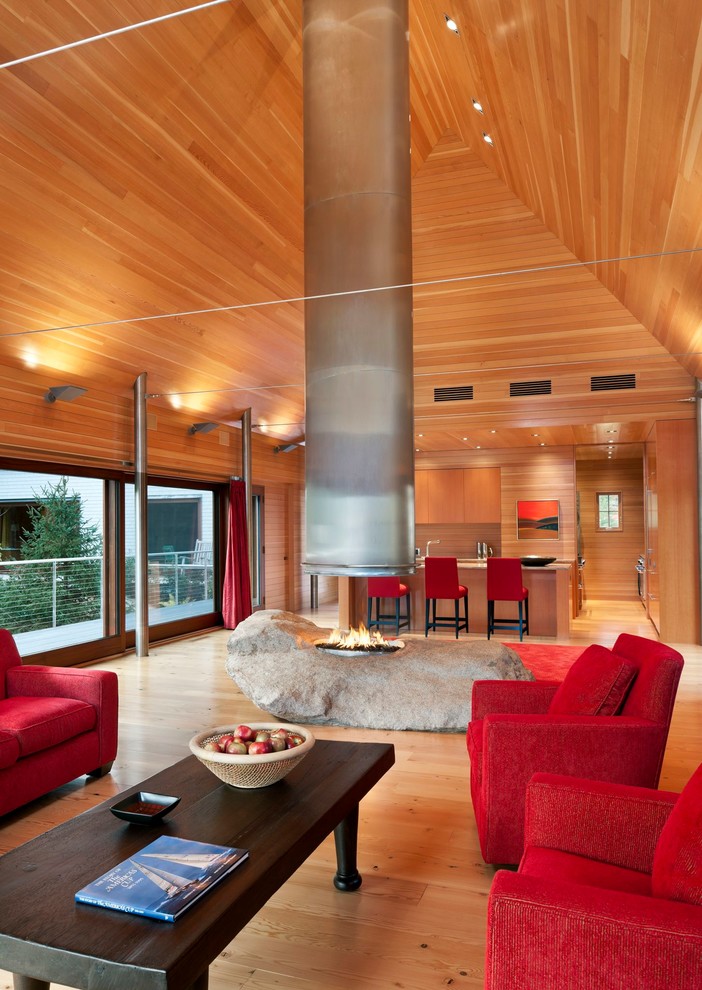 Cette photo montre un salon chic ouvert et de taille moyenne avec un sol en bois brun et une cheminée double-face.