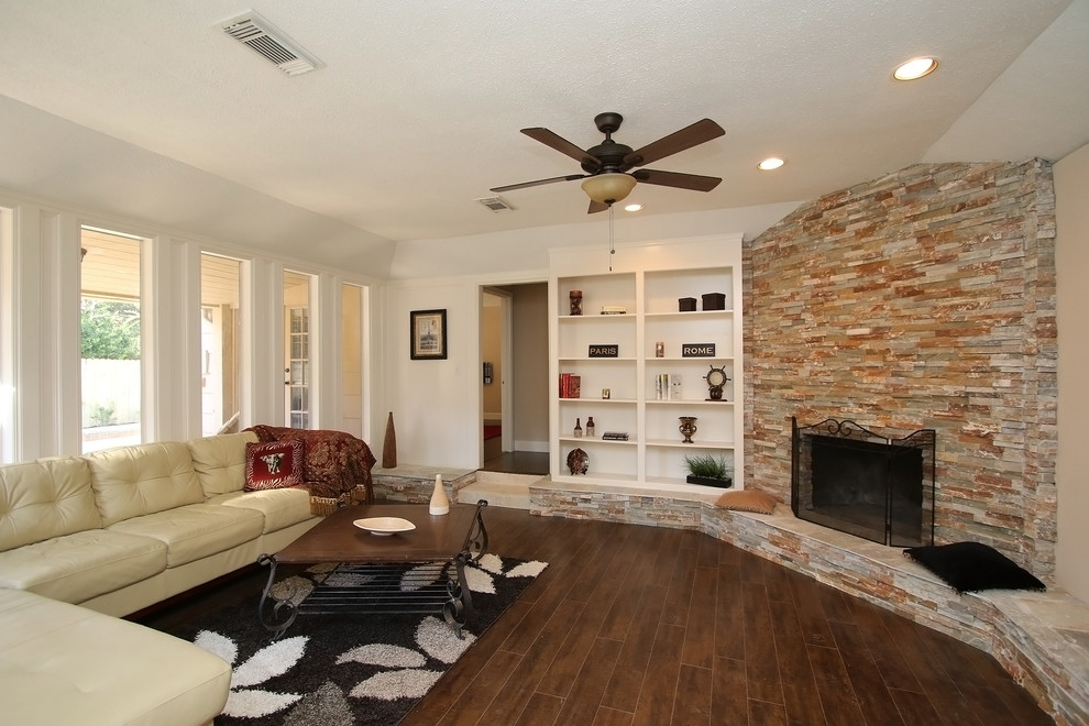 Example of a mid-sized tuscan formal and enclosed laminate floor and brown floor living room design in Other with white walls, a corner fireplace, a stone fireplace and no tv