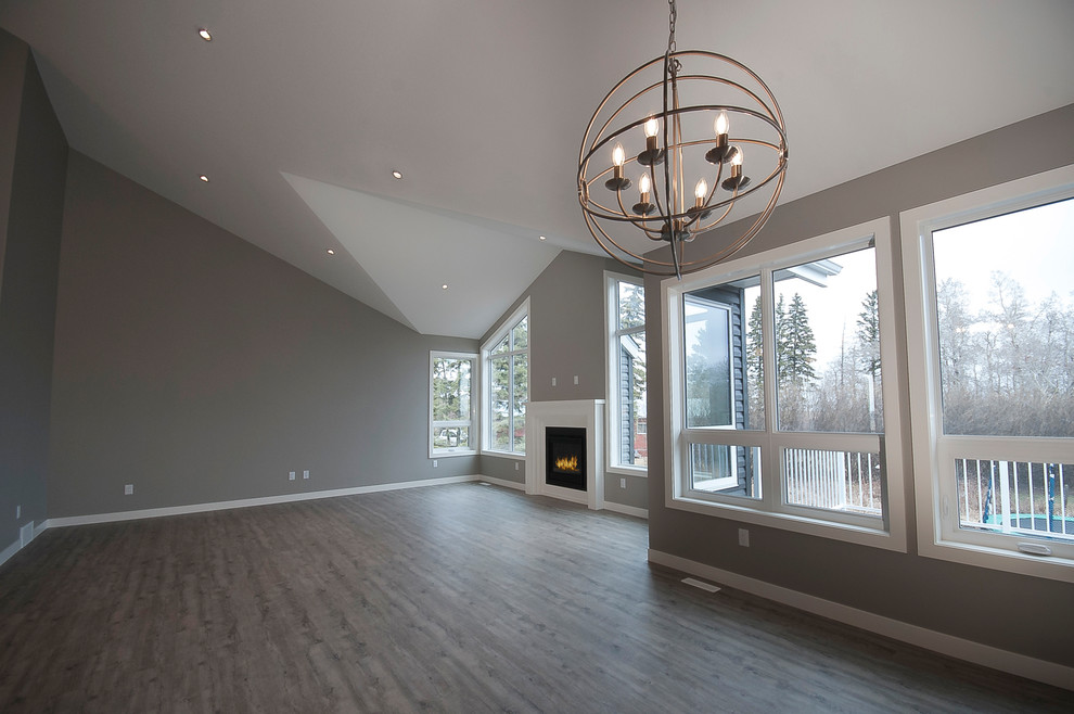 Mittelgroßes, Offenes Modernes Wohnzimmer mit grauer Wandfarbe, Kamin, Kaminumrandung aus Holz und grauem Boden in Calgary