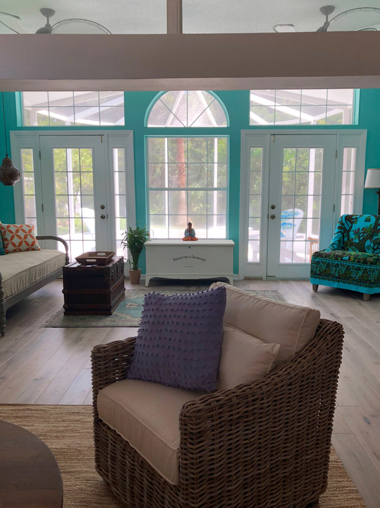 Foto di un piccolo soggiorno boho chic aperto con pareti bianche, pavimento in legno massello medio, TV a parete e pavimento grigio