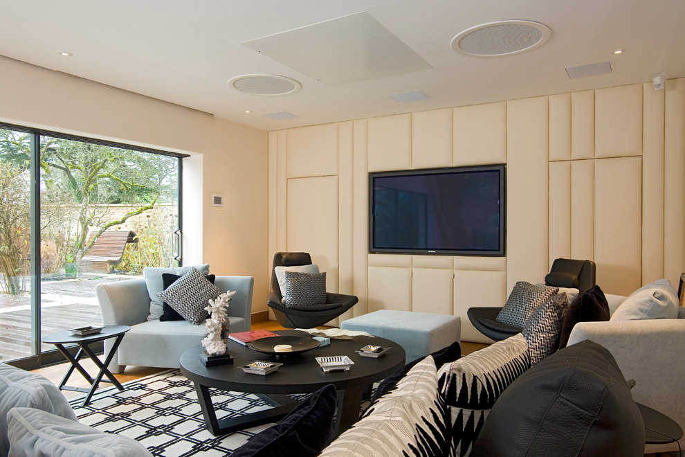 Diseño de salón actual con paredes beige y televisor colgado en la pared