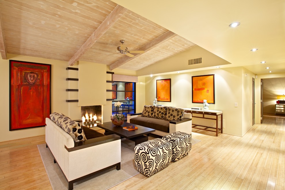 Ispirazione per un soggiorno design con pareti beige, pavimento in legno massello medio, camino classico e nessuna TV