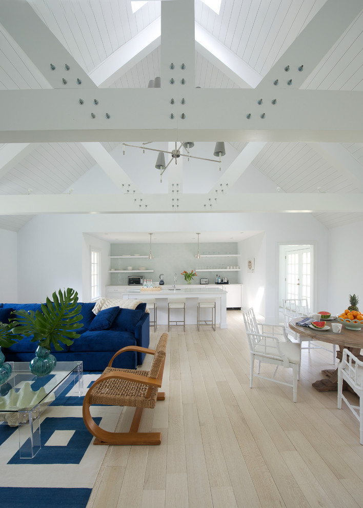 Immagine di un soggiorno costiero aperto con pareti bianche, parquet chiaro e pavimento beige