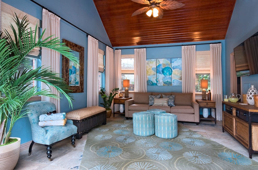Modelo de salón para visitas cerrado costero de tamaño medio sin chimenea con paredes azules, suelo de travertino, televisor colgado en la pared y suelo beige