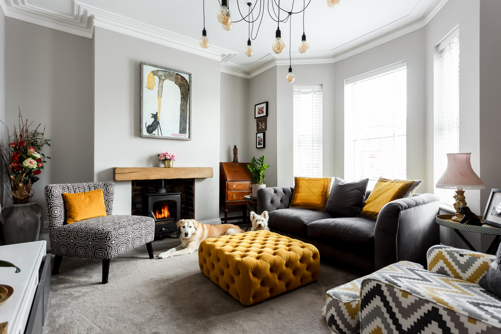 Example of a trendy formal carpeted living room design in Dorset with gray walls, a wood stove and no tv