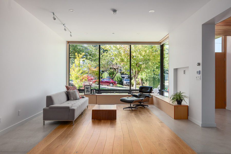 Ejemplo de salón tipo loft minimalista sin chimenea con paredes blancas, suelo de madera en tonos medios y pared multimedia