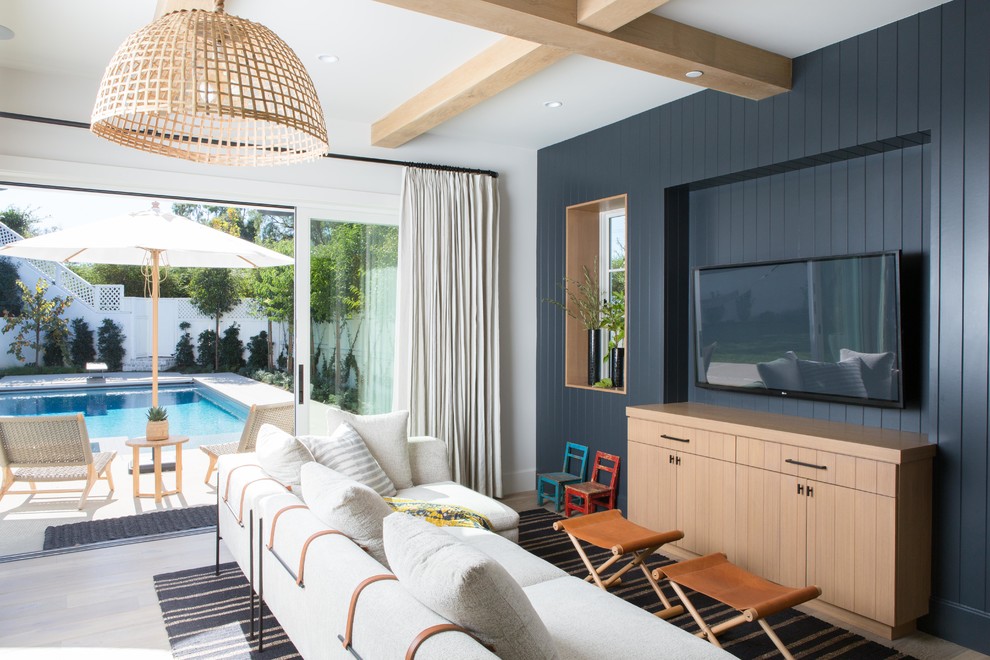 Идея дизайна: гостиная комната в морском стиле с синими стенами и телевизором на стене