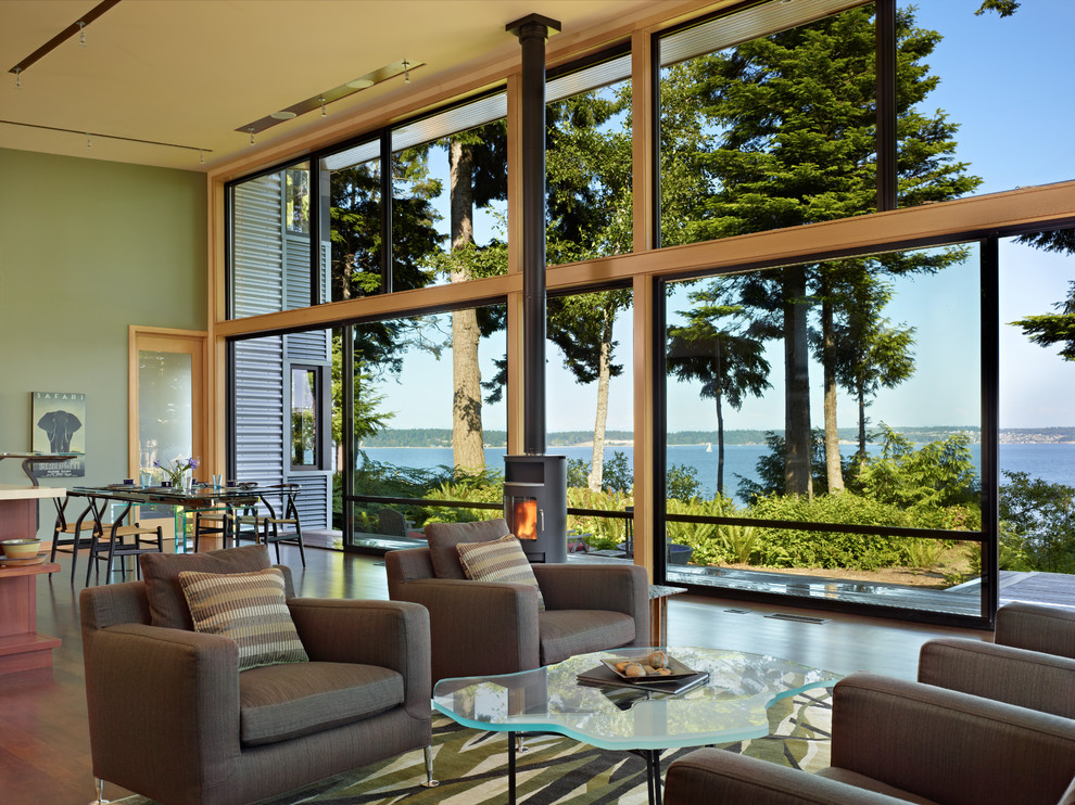 Идея дизайна: гостиная комната в стиле модернизм с зелеными стенами, печью-буржуйкой и ковром на полу
