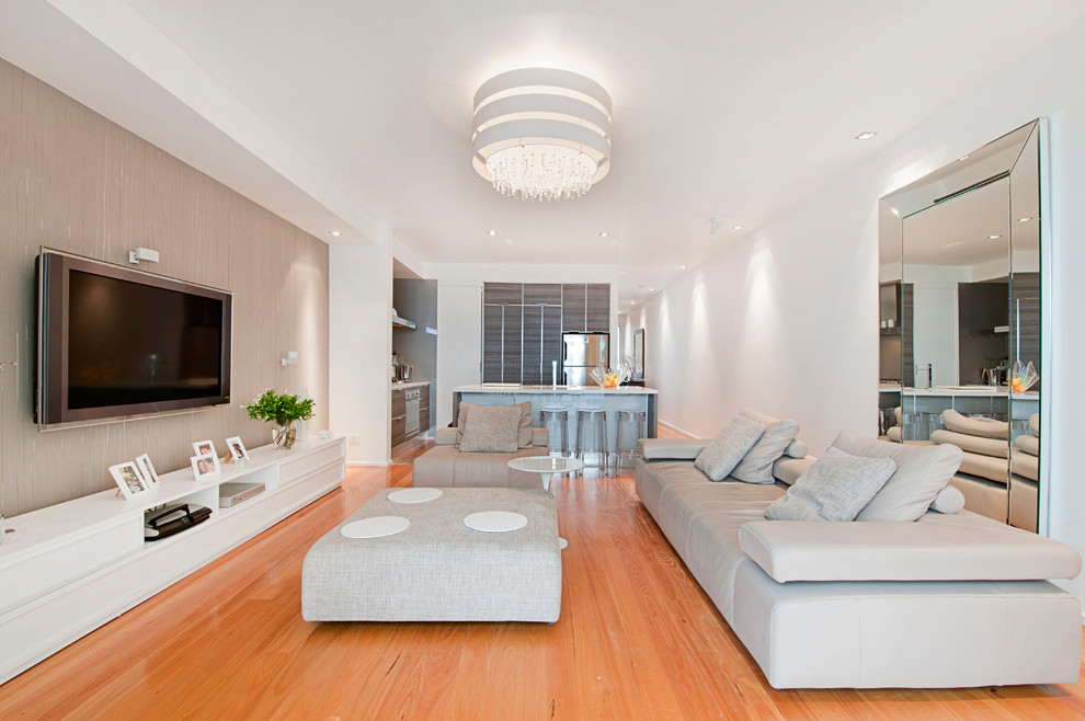 Idee per un grande soggiorno design aperto con pareti beige, parquet chiaro, nessun camino, TV a parete e sala formale