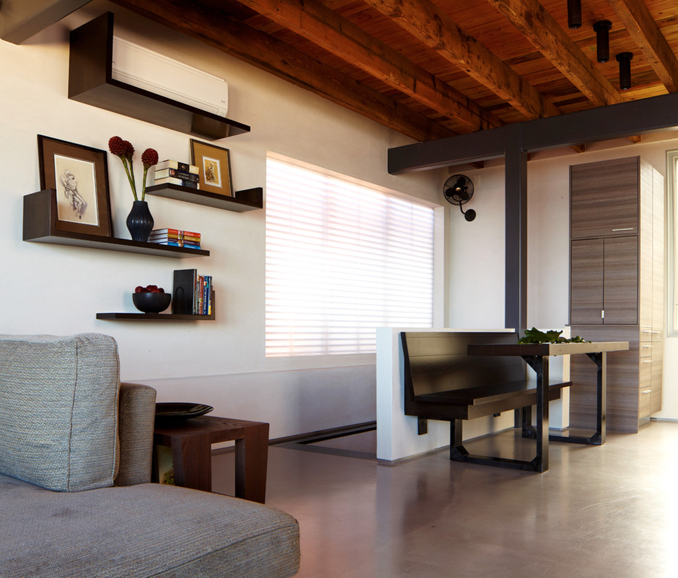 Стильный дизайн: гостиная комната в стиле модернизм с бетонным полом и белыми стенами - последний тренд