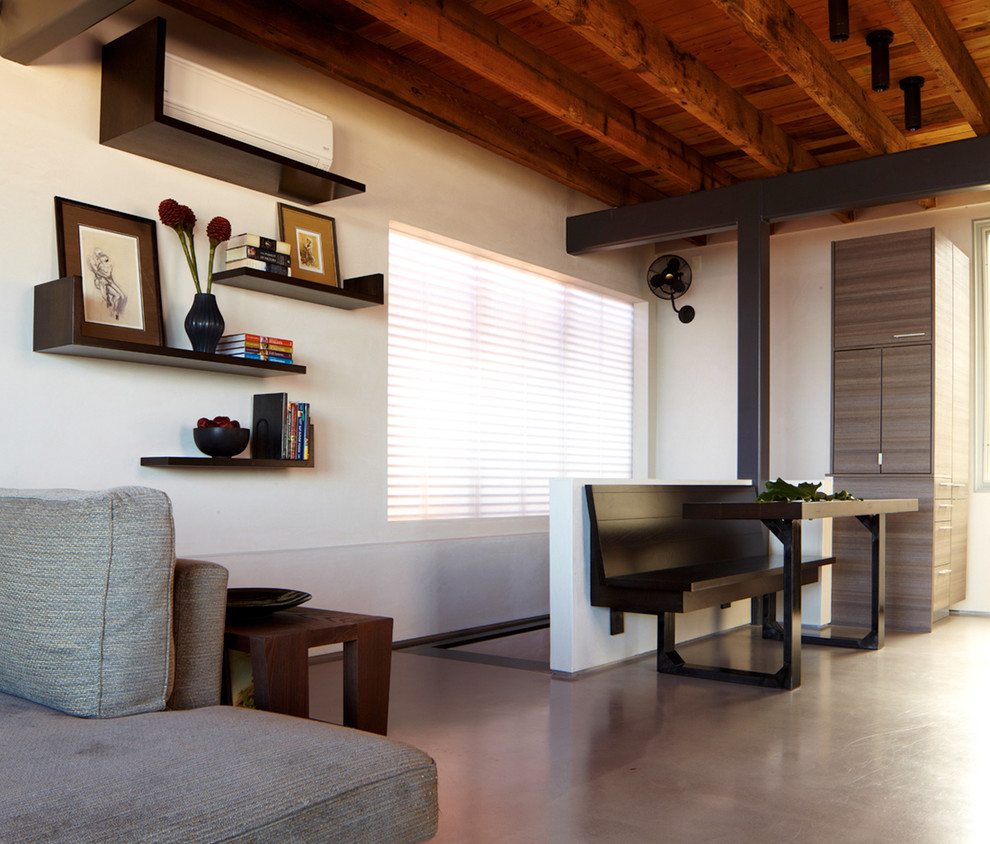 Example of a minimalist concrete floor living room design in New York with white walls