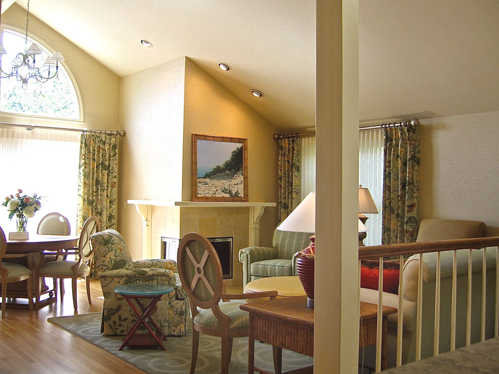 Klassisches Wohnzimmer mit gelber Wandfarbe, braunem Holzboden, Eckkamin und Kaminumrandung aus Stein in Cleveland
