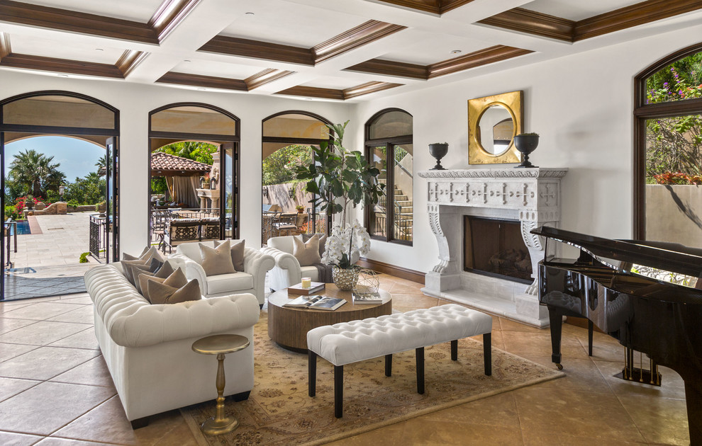 This is an example of a mediterranean open plan living room in Los Angeles with white walls, a standard fireplace and brown floors.