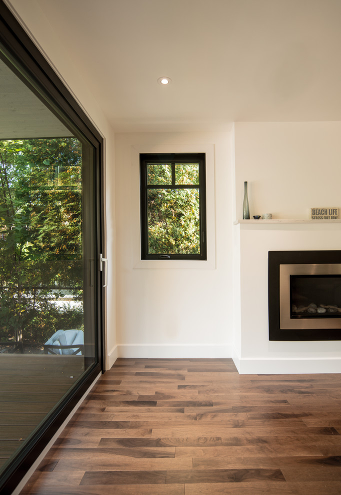 Example of a mid-sized trendy formal and enclosed dark wood floor and brown floor living room design in Montreal with white walls, a ribbon fireplace, a metal fireplace and no tv