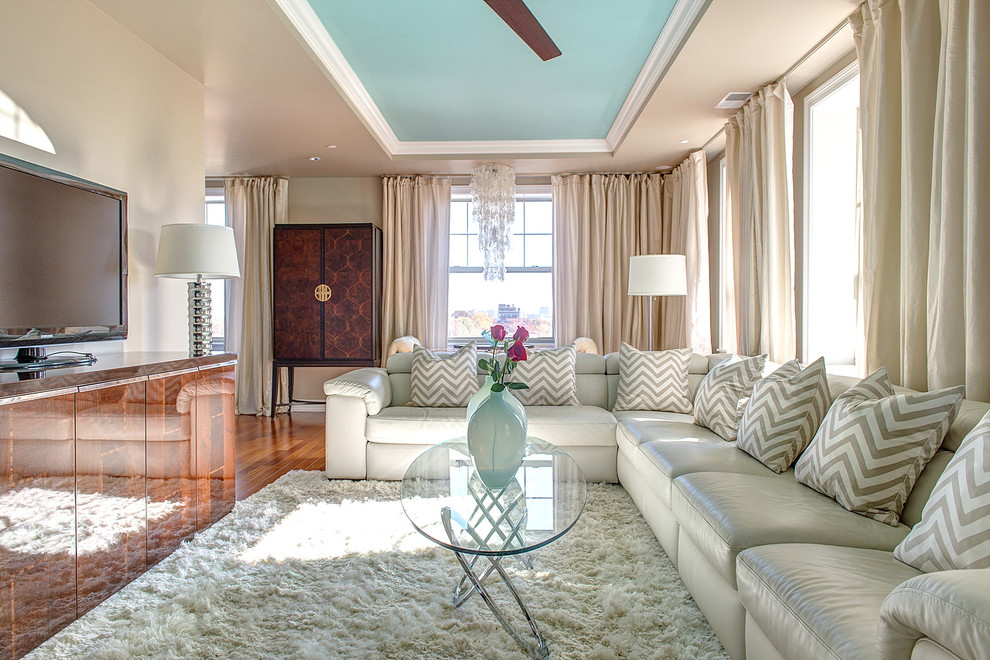 Ejemplo de salón cerrado actual de tamaño medio con paredes beige, televisor independiente, suelo de madera en tonos medios, suelo marrón y alfombra