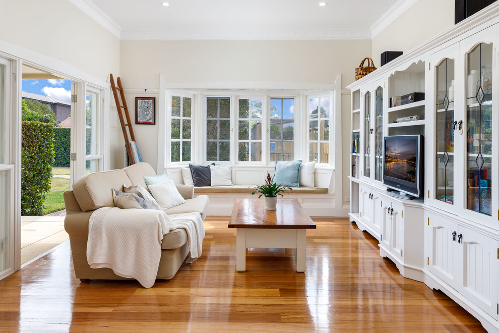 Klassisches Wohnzimmer mit beiger Wandfarbe, braunem Holzboden, Multimediawand und braunem Boden in Sydney