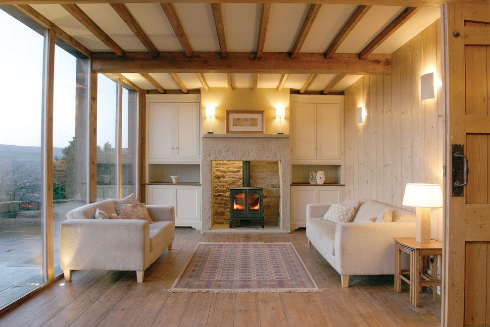 Inspiration pour un salon nordique avec une salle de réception, un mur beige, parquet clair, un poêle à bois et éclairage.