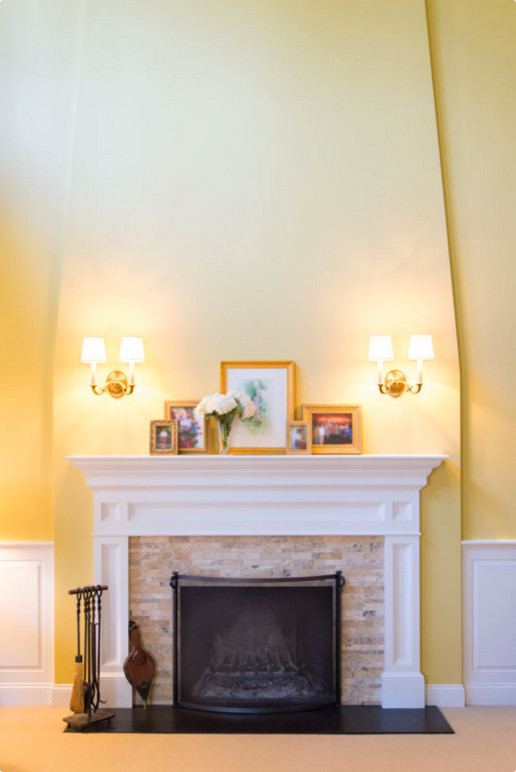 Cette photo montre un grand salon chic ouvert avec un mur jaune, moquette, une cheminée standard, un manteau de cheminée en brique et aucun téléviseur.