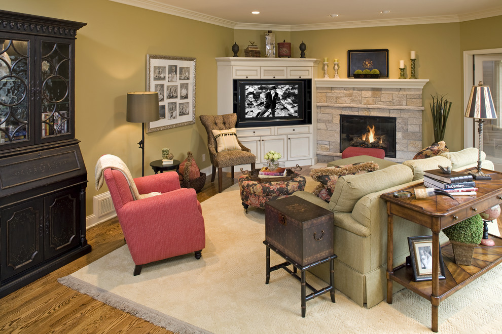 This is an example of an eclectic living room in Minneapolis with a stone fireplace surround and feature lighting.