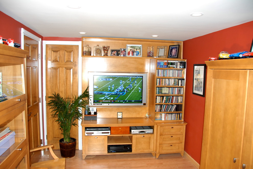 Imagen de salón cerrado actual de tamaño medio sin chimenea con parades naranjas, suelo de madera clara y pared multimedia
