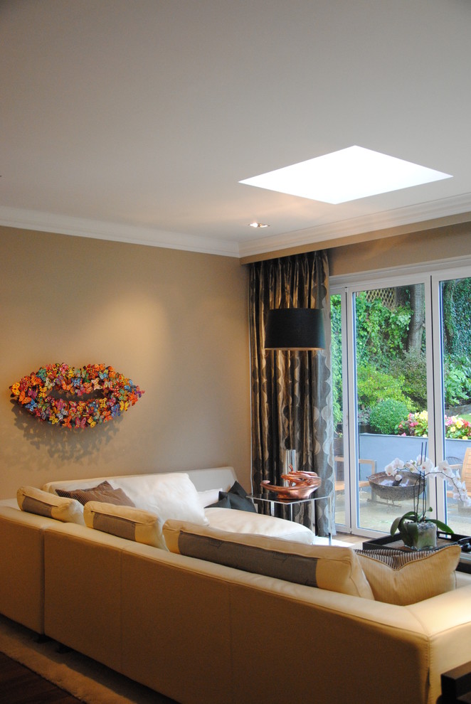Diseño de salón abierto contemporáneo de tamaño medio con paredes beige, suelo de madera oscura y televisor independiente