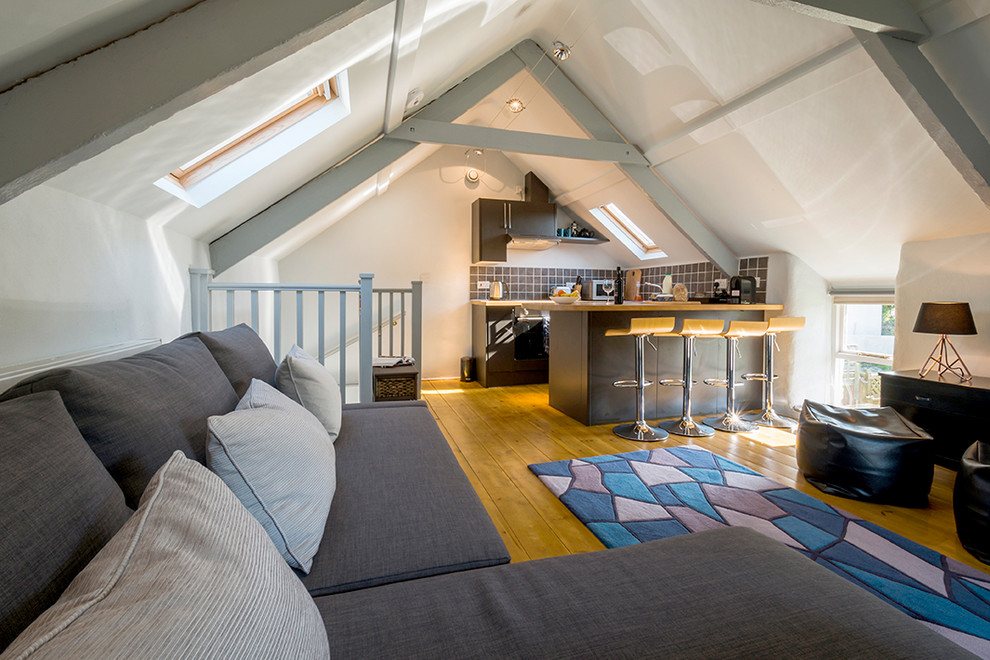 Kleines, Offenes Modernes Wohnzimmer ohne Kamin mit weißer Wandfarbe, hellem Holzboden und braunem Boden in Cornwall