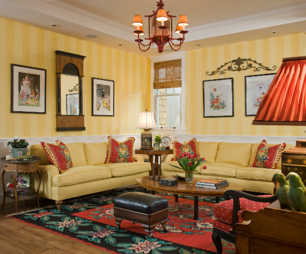 Immagine di un soggiorno eclettico di medie dimensioni e chiuso con pareti gialle, pavimento in legno massello medio, sala formale, nessun camino, nessuna TV e pavimento marrone