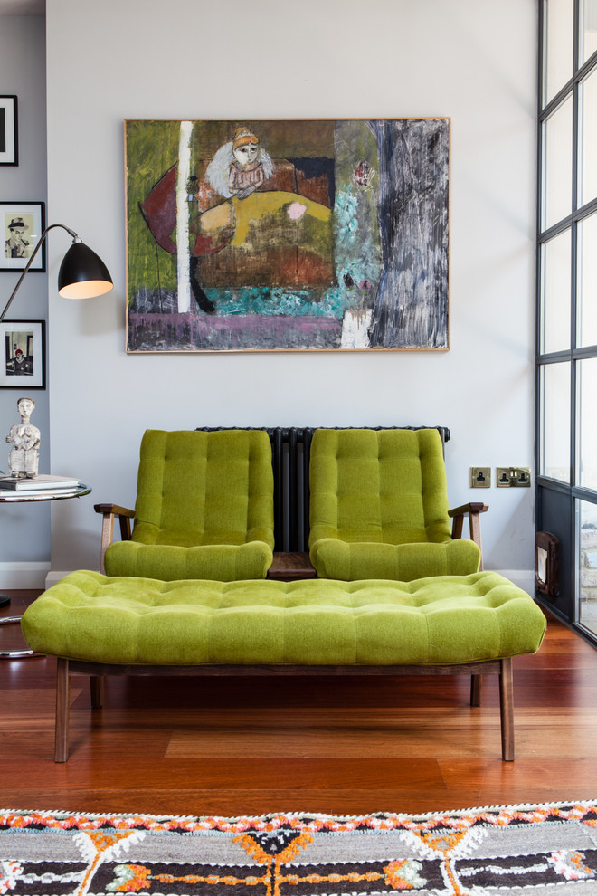 Cette image montre un salon design avec une salle de réception, un mur gris et un sol en bois brun.