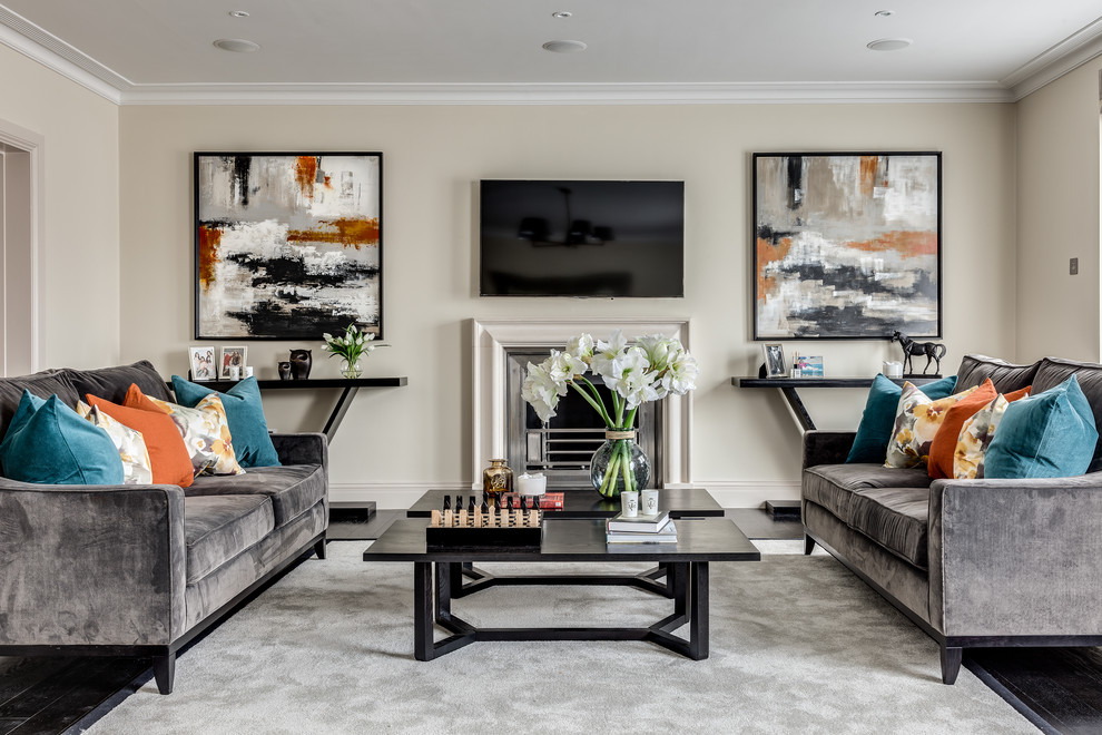 Inspiration for a classic formal and grey and teal living room in London with beige walls, dark hardwood flooring, a standard fireplace and a wall mounted tv.