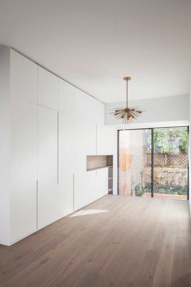 Idées déco pour un petit salon contemporain avec un mur blanc, parquet clair et un sol marron.