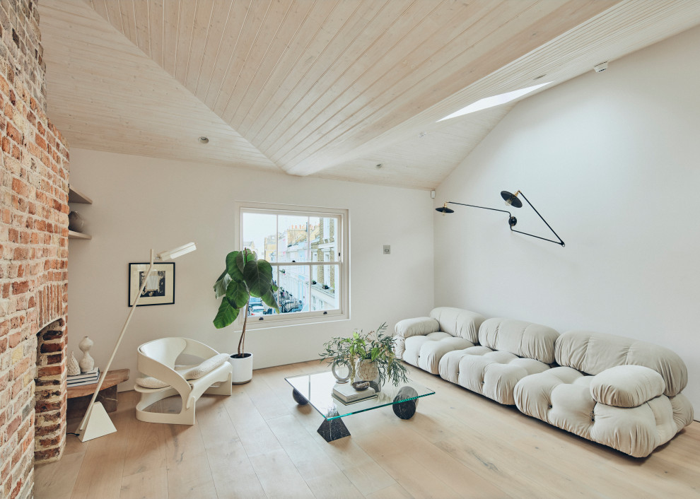 Immagine di un soggiorno contemporaneo aperto con pareti bianche, parquet chiaro, pavimento beige, nessun camino e cornice del camino in mattoni