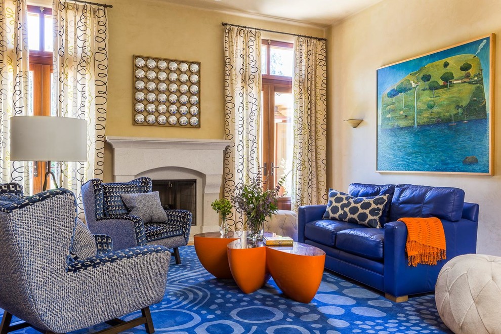 На фото: большая открытая, парадная гостиная комната в стиле фьюжн с желтыми стенами, стандартным камином, фасадом камина из бетона, ковровым покрытием, синим полом и синим диваном