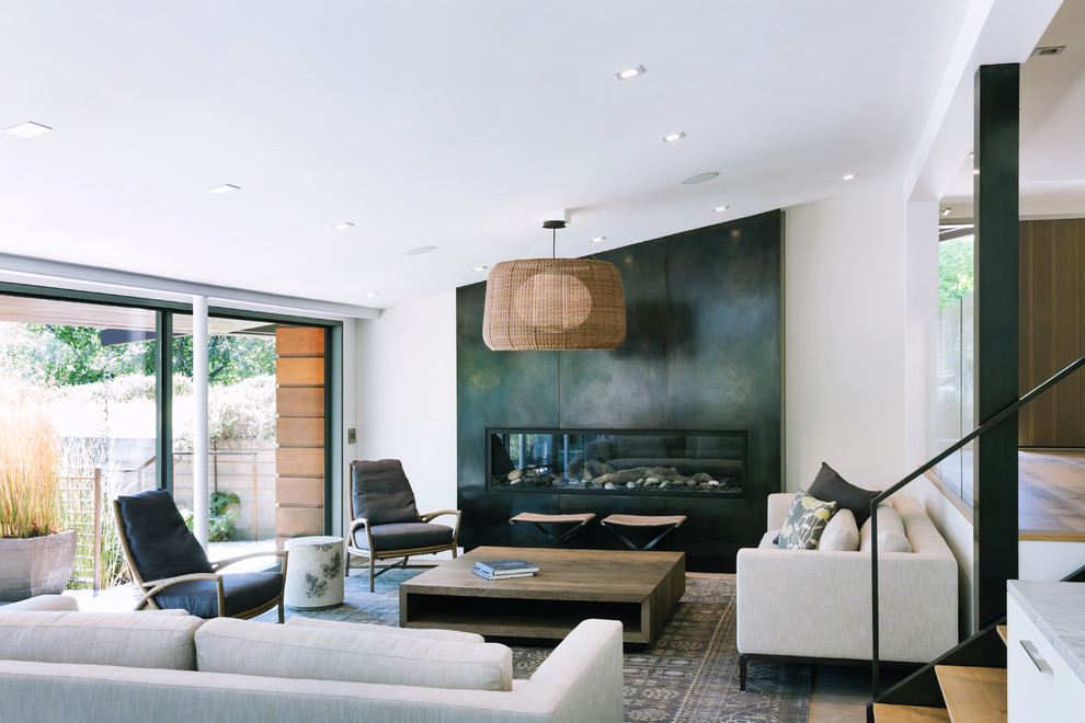 Cette photo montre un salon tendance ouvert avec sol en béton ciré, un manteau de cheminée en métal, un mur blanc, une cheminée ribbon et un sol gris.