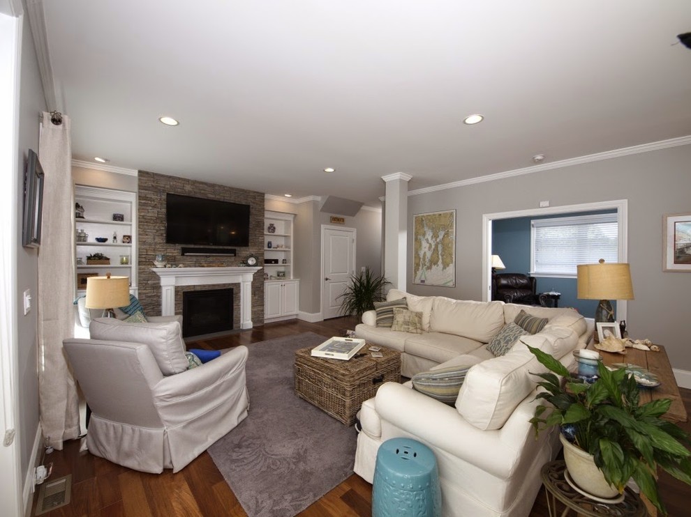 Design ideas for a medium sized beach style open plan living room in Bridgeport with grey walls, medium hardwood flooring, a standard fireplace, a stone fireplace surround and a wall mounted tv.