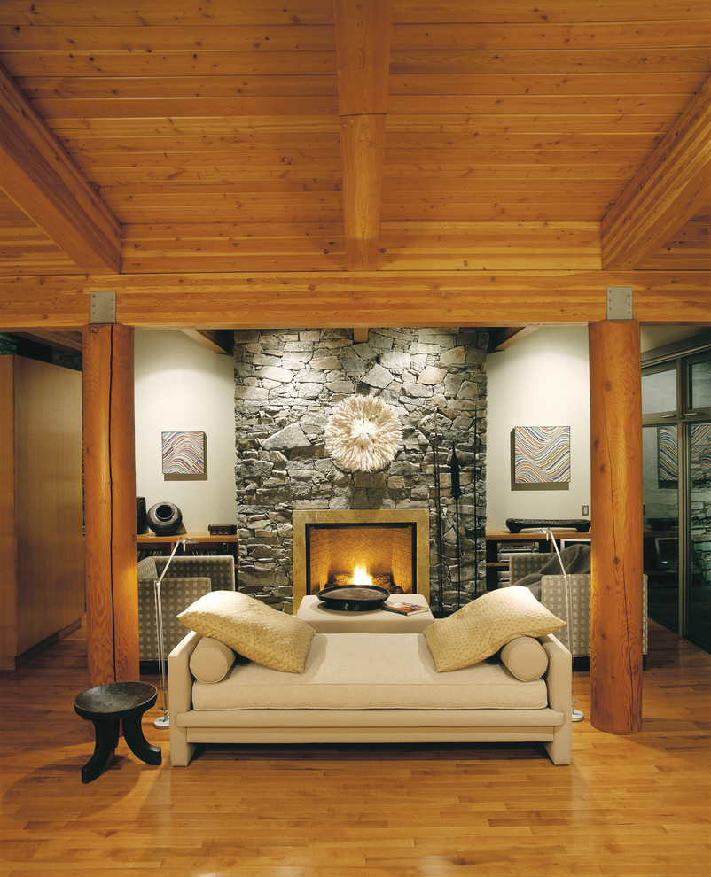 Large elegant open concept light wood floor living room photo in Calgary with beige walls and a stone fireplace