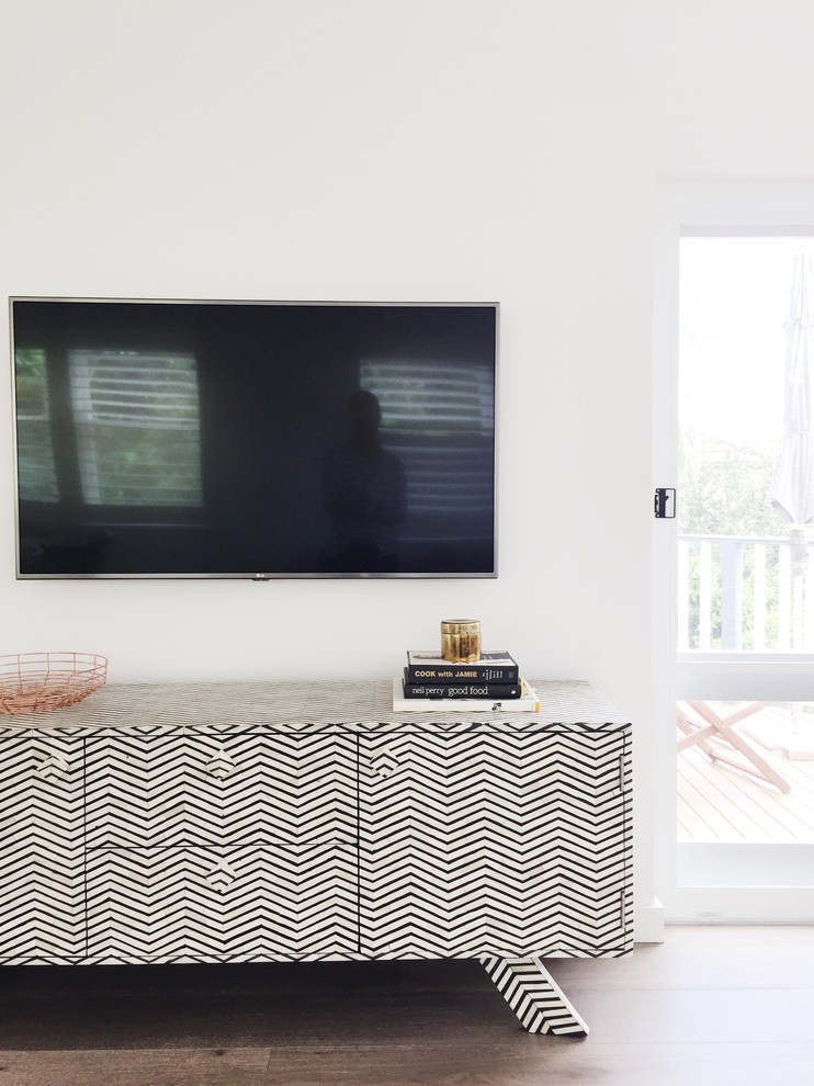 Foto de salón abierto nórdico de tamaño medio con paredes blancas, suelo de madera en tonos medios y televisor colgado en la pared