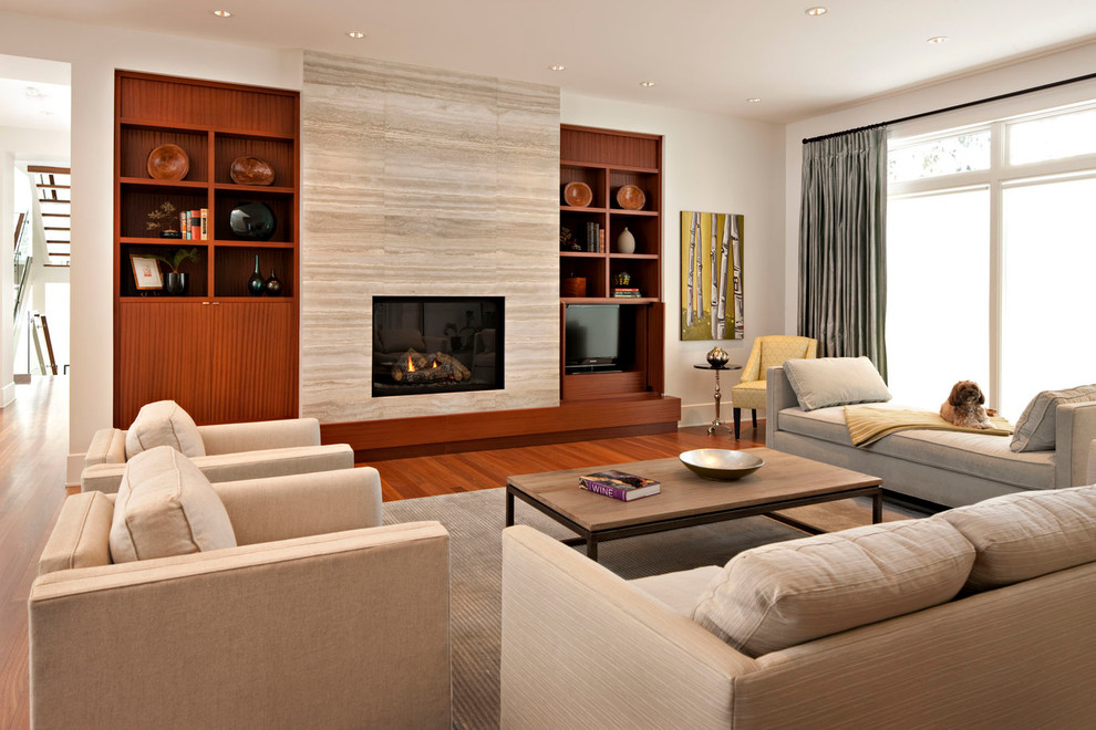 Repräsentatives, Offenes Modernes Wohnzimmer mit weißer Wandfarbe, braunem Holzboden, Kamin, Kaminumrandung aus Stein und Multimediawand in Calgary