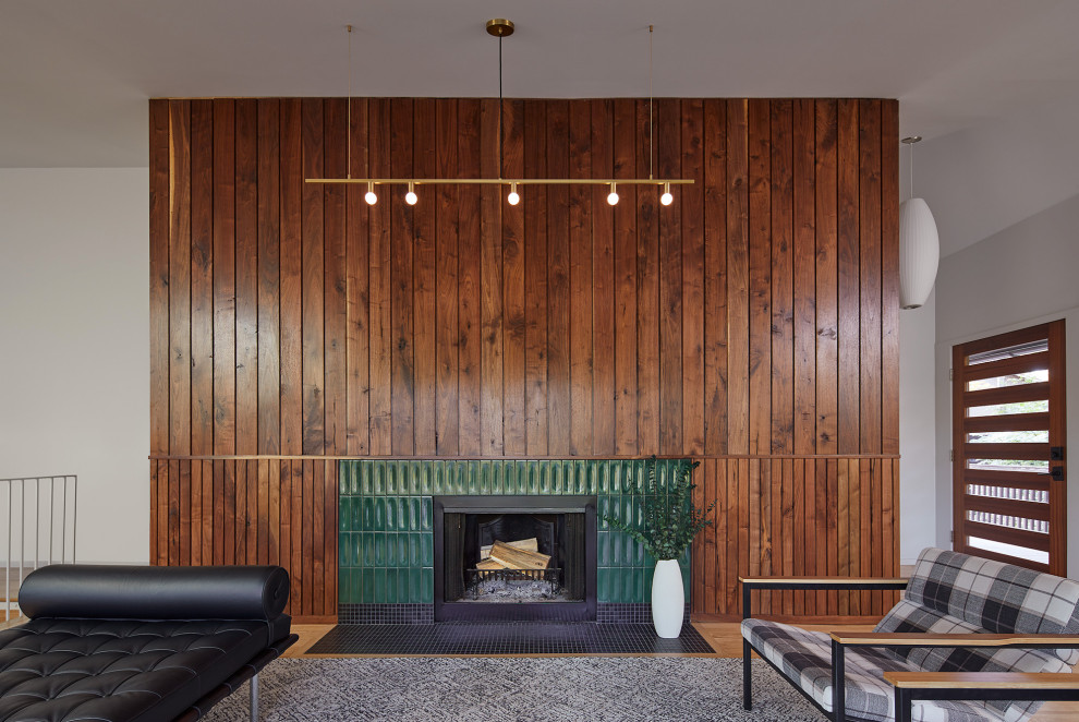Свежая идея для дизайна: гостиная комната в стиле ретро с светлым паркетным полом, стандартным камином и фасадом камина из плитки - отличное фото интерьера