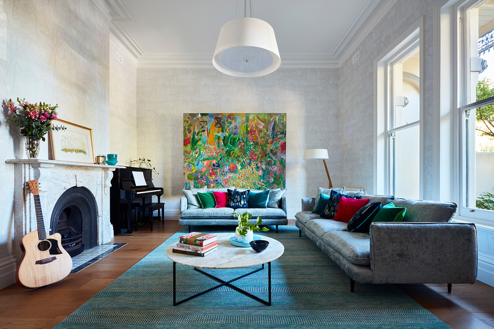 Klassisches Wohnzimmer mit braunem Holzboden, Kamin, Kaminumrandung aus Stein, beiger Wandfarbe und braunem Boden in Melbourne